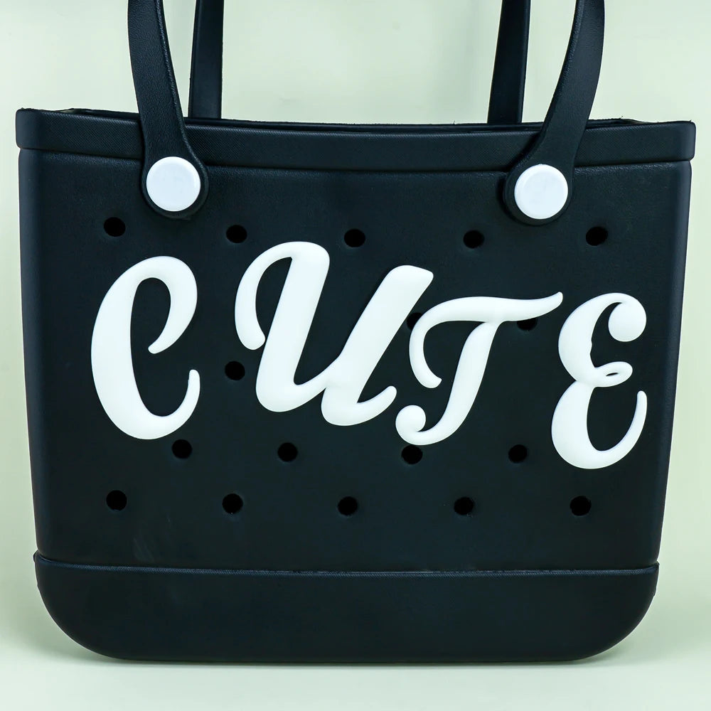 Ein weißer römischer Alphabet-Charm für Strandtaschen. Perfekt, um Ihre Tasche zu personalisieren. Einfach anzubringen und ideal für Accessoires.

