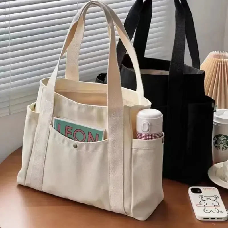 Große Canvas-Tragetasche mit viel Stauraum. Ideal für Arbeit, Freizeit und Studium. Schlichtes, vielseitiges Design, perfekt für Bücher und Kleidung.