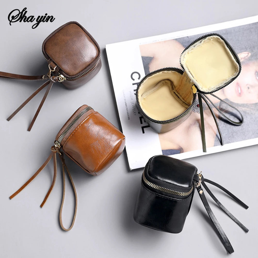 Kleine, quadratische Aufbewahrungstasche aus Leder. Tragbar und hängbar, ideal als Mini-Geldbörse, Kopfhörer-Organizer oder für Make-up. Ein unverzichtbares Reiseaccessoire.